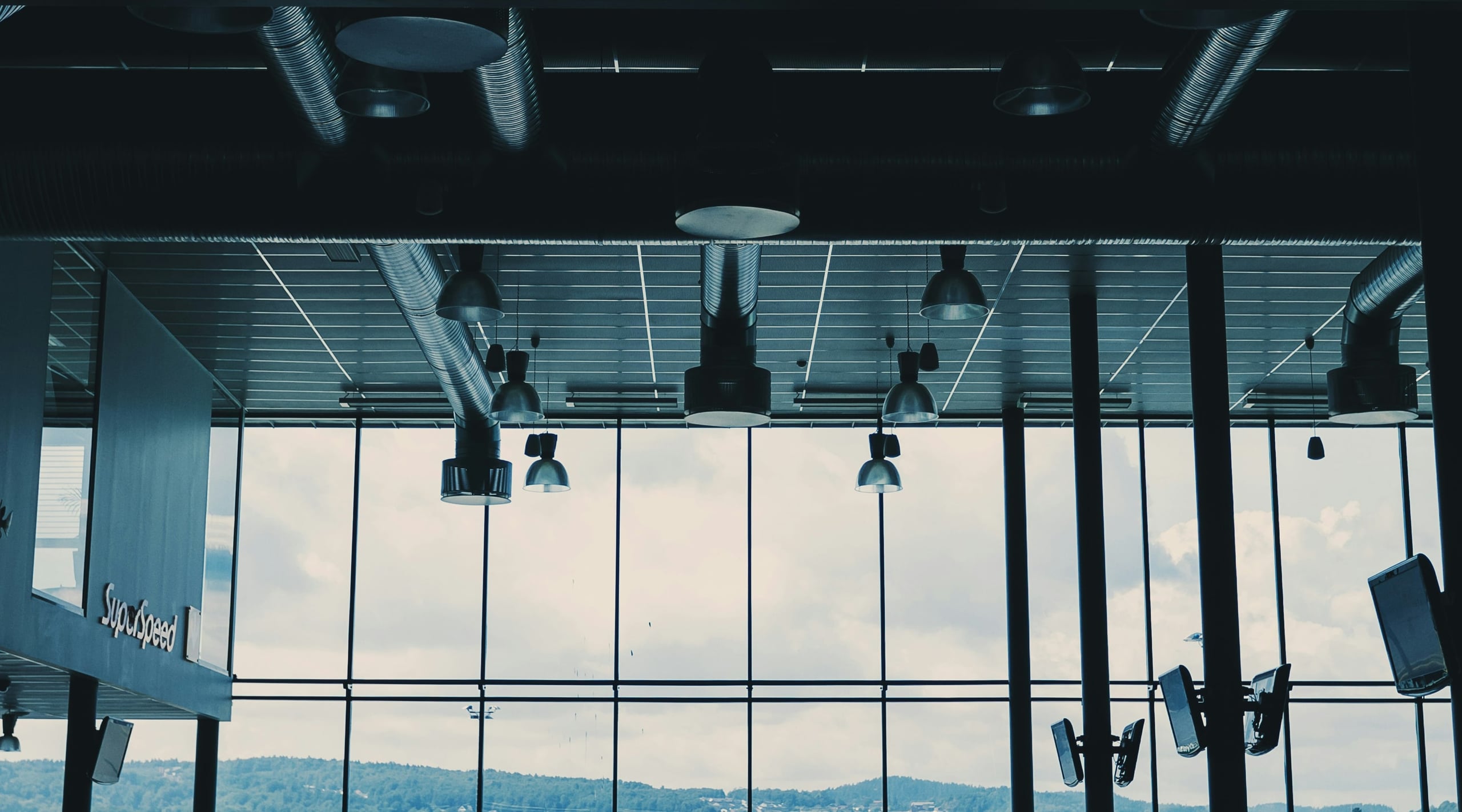 Grande atrio vetrato con condotte di ventilazione a vista