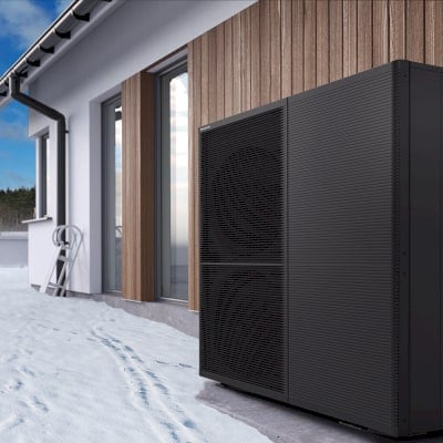 Pompa di calore esterna accanto a una facciata in legno