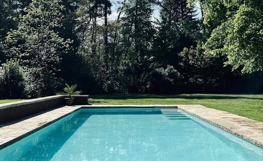 Piscina in un giardino alberato