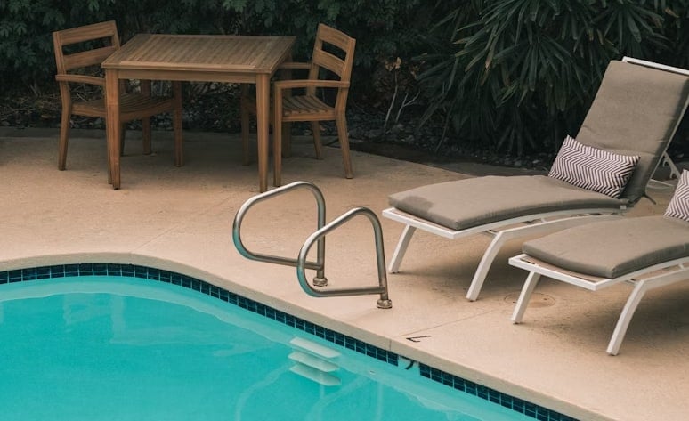 Bordo piscina con lettini e tavolo