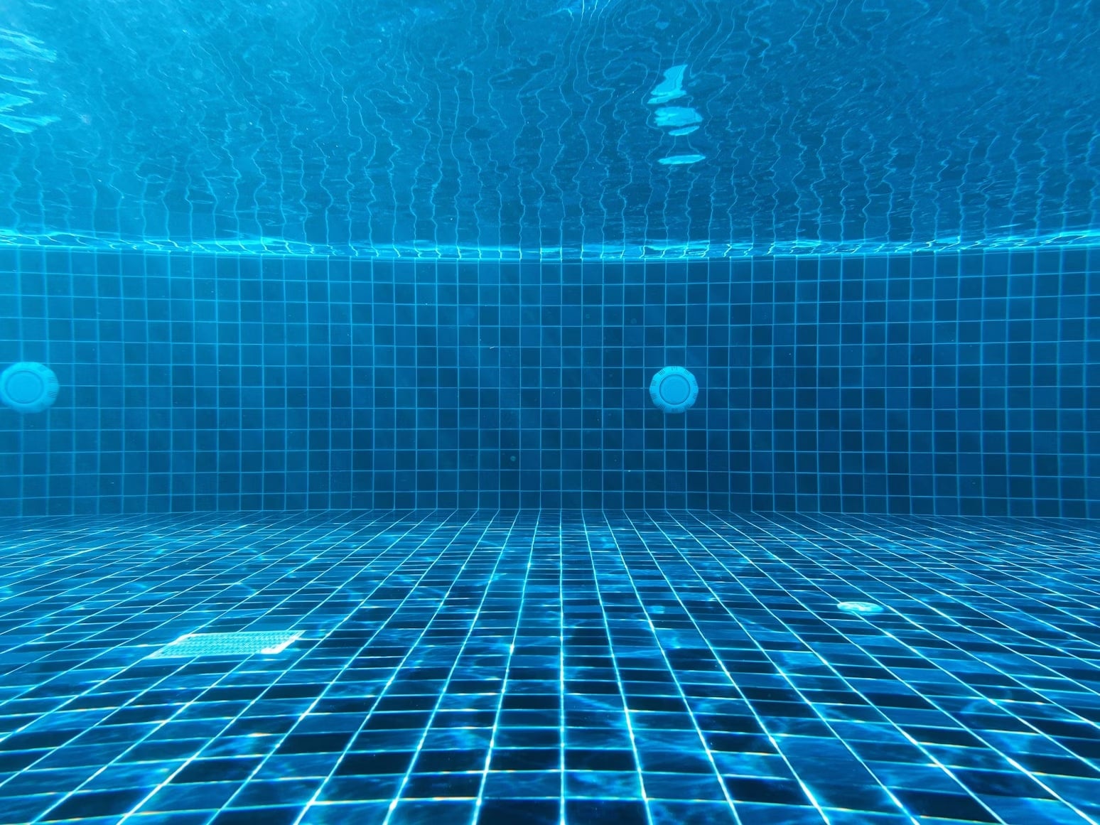 Fondo di una piscina con piastrelle blu