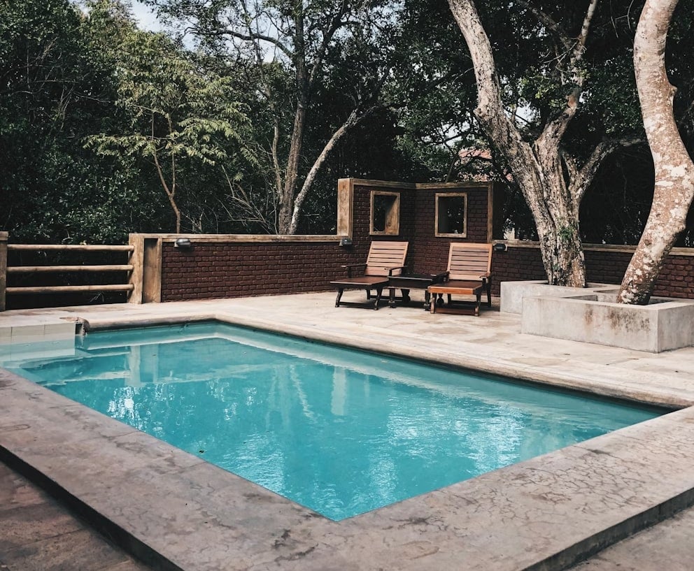 Piscina in un giardino con lettini in legno